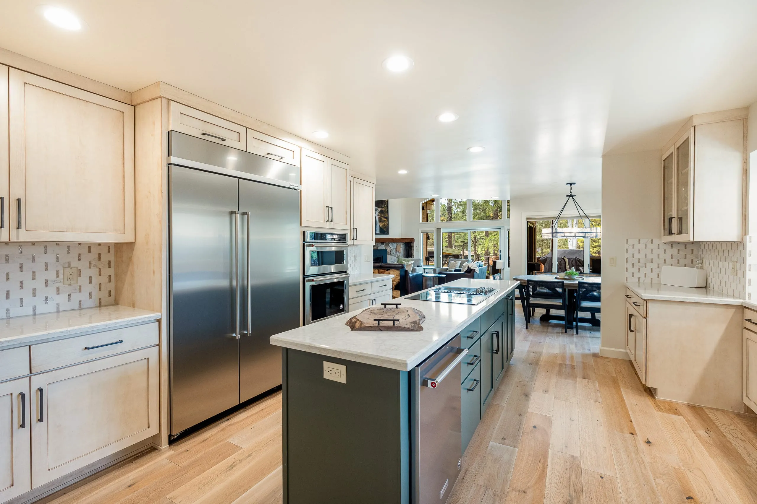 Kitchen with a stainless refrigerator, a dark island and an open view to the dining area
