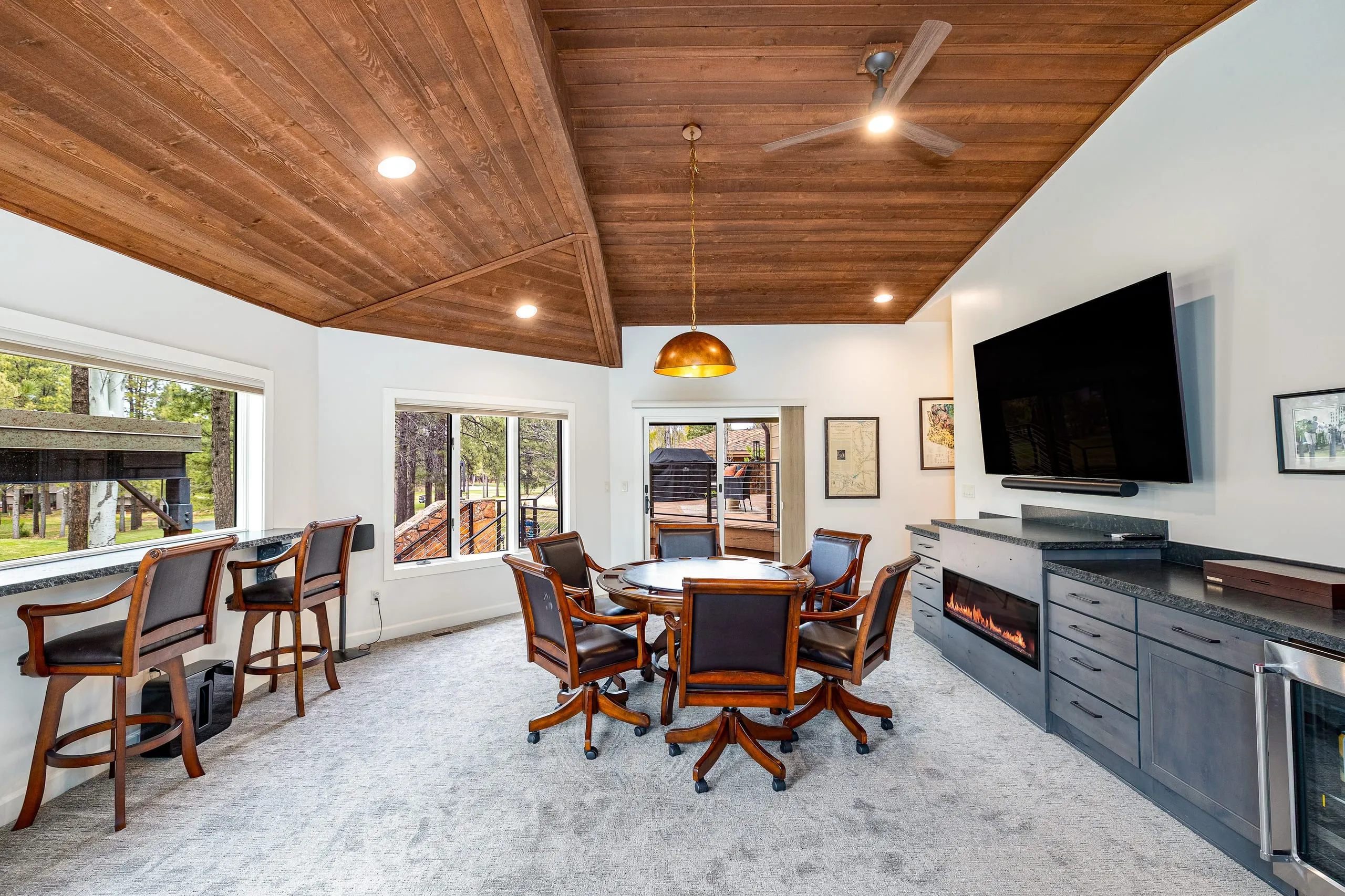 Game room with a card table, bar seating and a wood-paneled ceiling